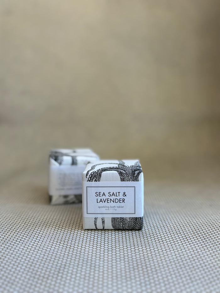 two small square packages of Formulary 55 sea salt and lavender sparking bath tablets with white and black design on packaging.