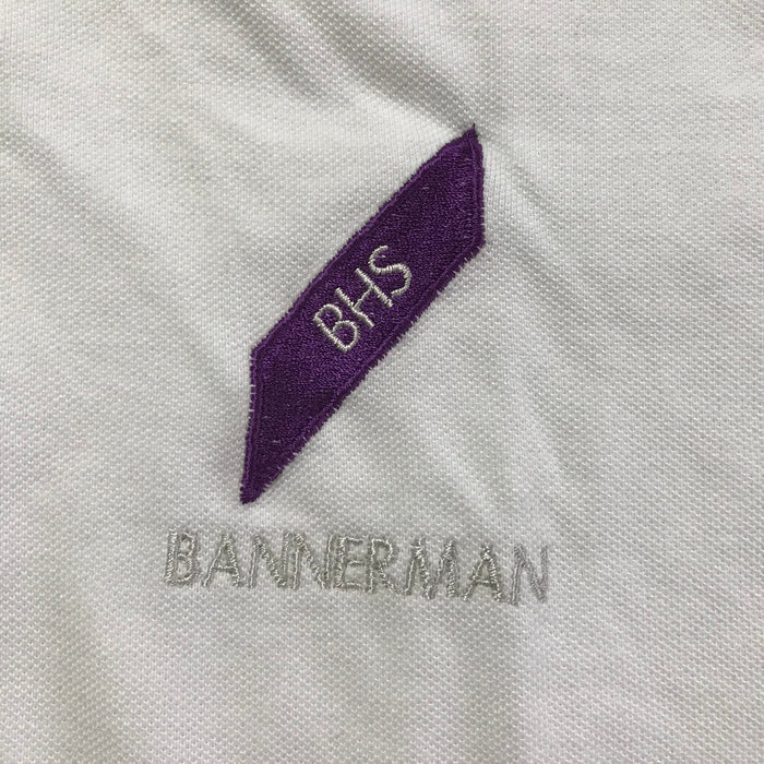 Second-hand Bannerman High School white polo shirt, close-up view of the embroidered school crest.