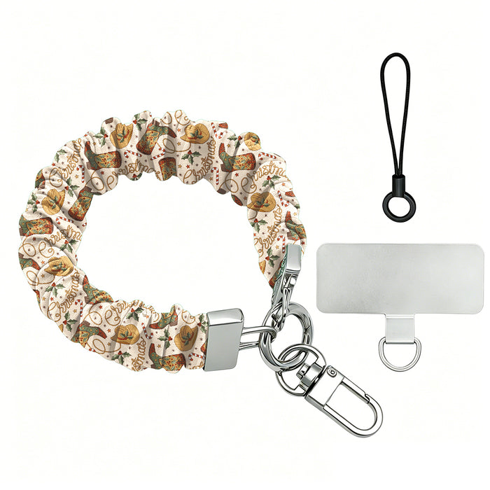Boot Scootin' Christmas scrunchie phone wrist strap laid flat with silver clasp and phone tab, cowboy boots and hats on cream