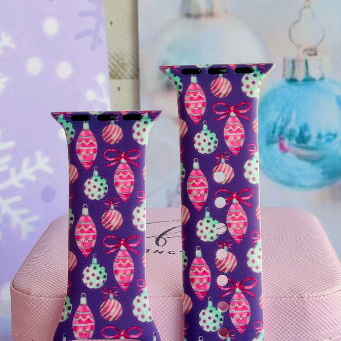 Close-up of both Just One More Ornament Apple Watch band straps with polka-dot baubles, striped globes and ribbon bows