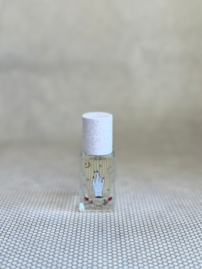 small glass bottle of maison matine perfume with hand drawing design on bottle.