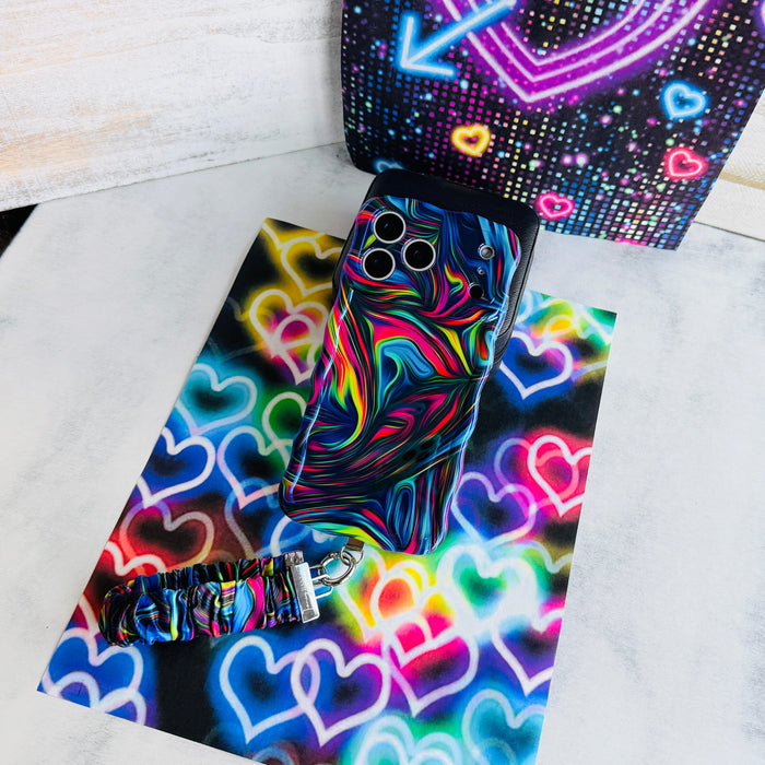Neon Taffy scrunchie phone wrist strap laid out with the matching neon swirl Wavy Luxe iPhone case on a glowing neon heart backdrop