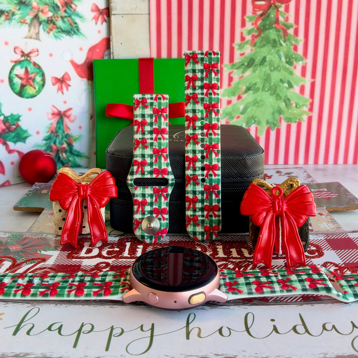 Plaid Tidings & Bows Samsung Galaxy Watch band on a rose gold Galaxy Watch, with both straps on a black jewelry box