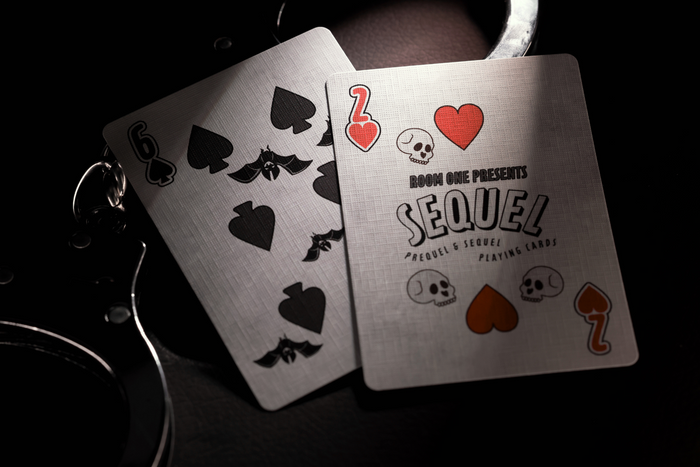 Two Sequel Edition number cards with black spade symbols on a dark background
