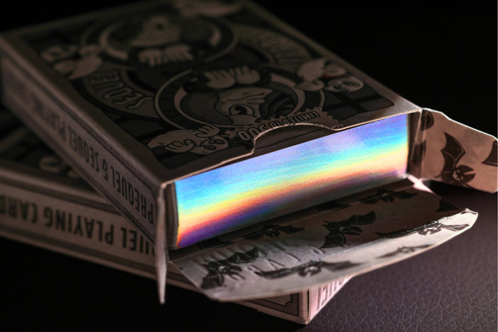 Sequel Gilded Edition playing card metallic holographic gilded cards inside their tuck box on a dark background