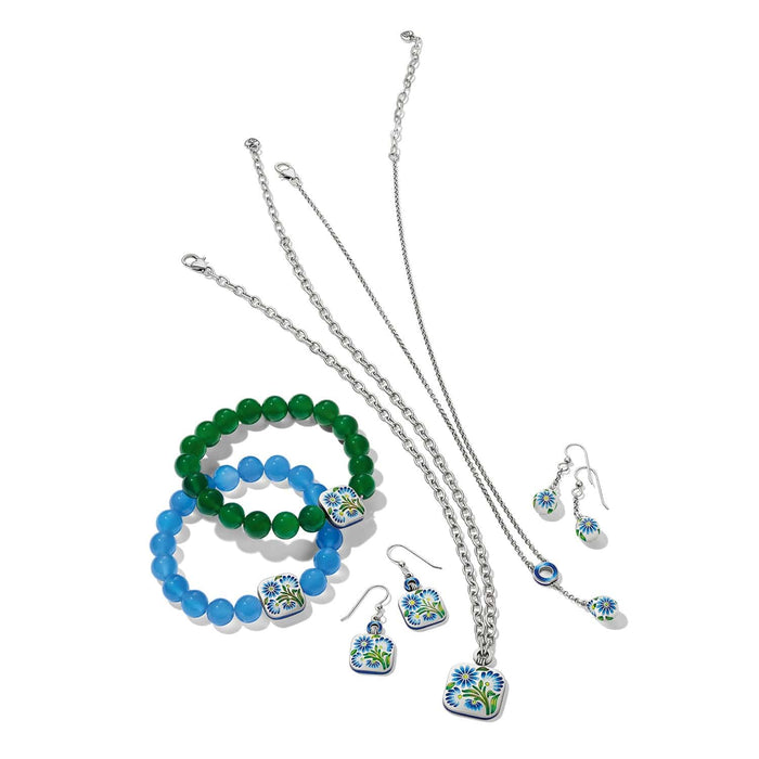 Brighton silver-plated jewelry set styled with blue and green beaded bracelets and floral enamel pendants on white background
