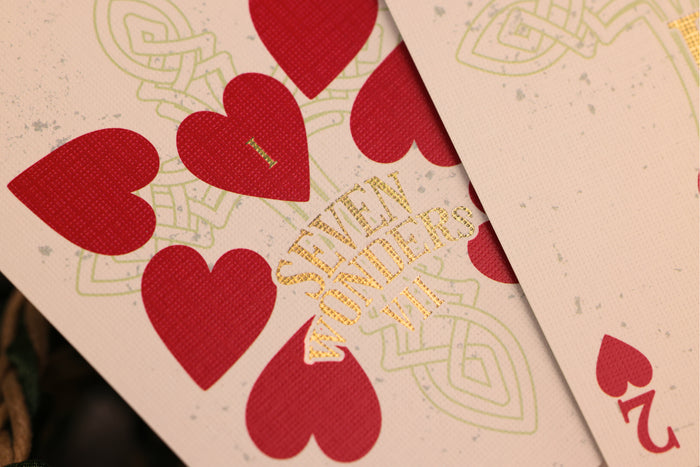Close-up of playing cards with red hearts and gold foil detailing.