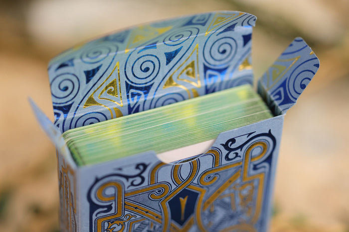 Decorative deck of cards with blue, yellow, and gold patterns on a blurred background