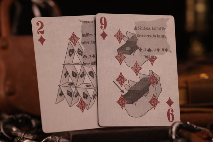 Two number cards with playing card and card magic designs on a blurred background